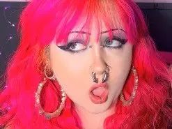 biancablacks shows off her bright pink hair and heavy eye makeup while wearing large silver hoop earrings and a silver nose ring.