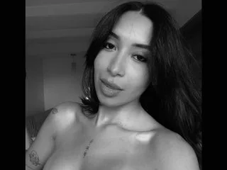 celinvega poses shirtless with long dark hair looking into the camera.