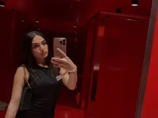 dirtyyiyannaa poses for a mirror selfie wearing a black tank top, showing her long dark hair and face against a red background.