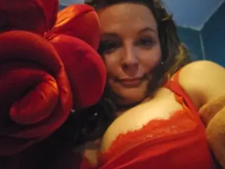 dulce_blanca poses close up, wearing red lace lingerie and showing her cleavage and face with her hair down.