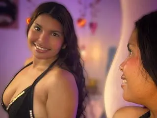 Smiling brunette woman in a black halter top enjoying a cozy evening in a warm, purple-lit room.