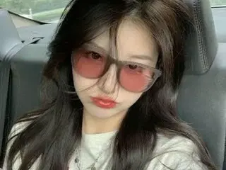 happygirl68 poses in a car wearing sunglasses and a white top, letting her long dark hair fall over her shoulders.
