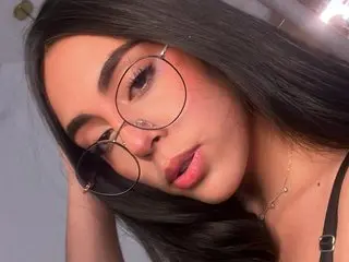 imxvalery poses with long black hair and dark eyebrows, looking directly at the camera with a close-up view of her face and shoulders.