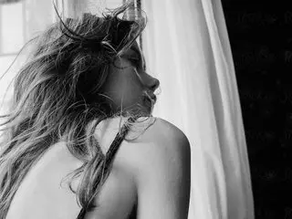 indian_tara poses with her long, wavy hair, showing her bare shoulders and neck in a close-up black and white shot.