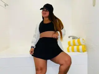 jade_wilson wearing a black crop top and shorts while sitting on the edge of a white bathtub.