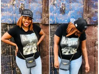 jellymaroon poses in a black Beatles t-shirt and a black baseball cap, standing against a blue textured wall.