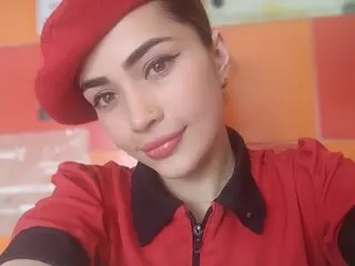 Smiling young woman in a red uniform and matching beret posing in a bright cafe setting.