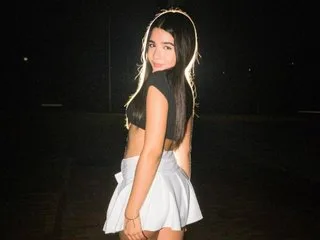 linaxxl — linaxxl poses outdoors at night wearing a black crop top and a white skirt.