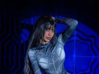 littleeemiily21 poses in a tight grey and black spiderweb bodysuit against a blue neon background.
