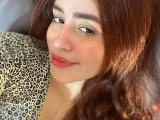 littlesangel poses with a soft smile, showing her face, hair, and shoulders in a close-up shot.