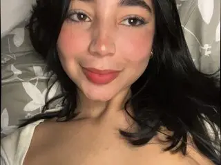 lysmoon smiles close up, showing her face and dark hair while posing in a white top.
