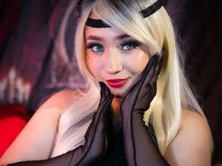 megannherrera wearing long black gloves and a headband, posing with her hands on her face and smiling.
