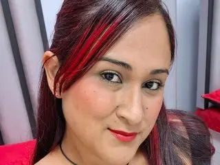 nahala_23 poses with a smile, showing her long red-streaked hair and dark eyes in a close-up headshot.