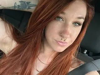 savannahsiren poses with her long red hair down, showing her face and neck while wearing a thin gold chain necklace.