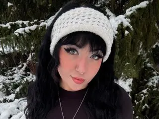 stargoddess_sage has long dark hair and a white knit headband, posing outdoors against a snowy forest background.
