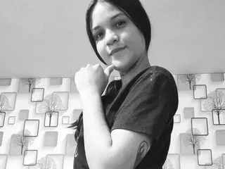 xplayxx22 poses with her hand under her chin, showing her face and shoulders against a patterned wall background.