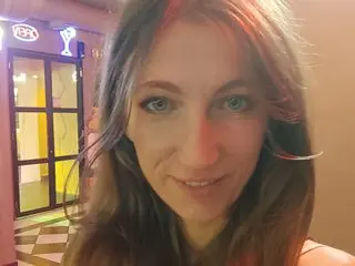 your_world looks directly at the camera with a smile, showing her face and long brown hair in a close-up shot.