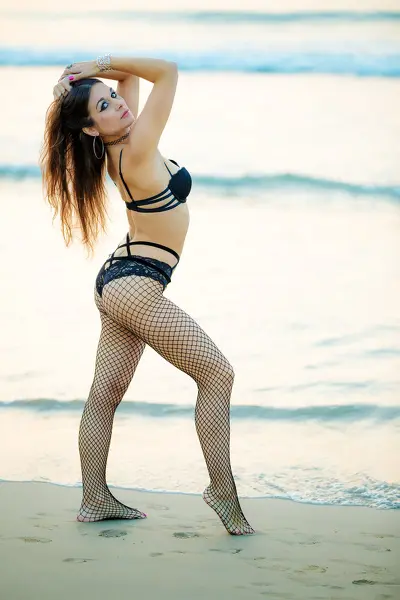 ClaraSweetTV poses outdoors with her legs spread, wearing a black tank top and showing her bare legs and smooth skin.