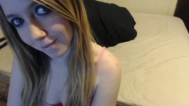 Juvia poses for a close-up selfie, showing her face and dark hair while wearing a black t-shirt against a light green wall.