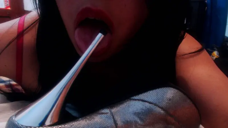 LatinaHot4U — Close-up of a woman with red lipstick holding a silver spoon near her mouth in a casual indoor setting.
