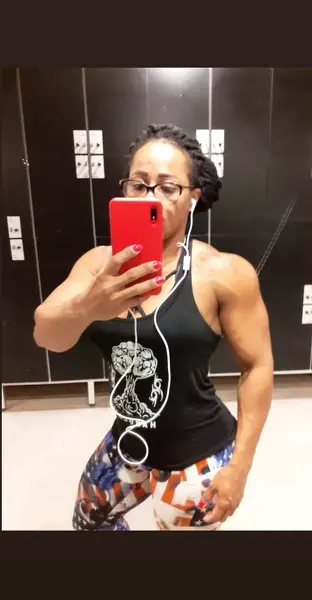 marta strong poses while flexing her muscular arms and showing her toned shoulders and chest in a close-up shot.